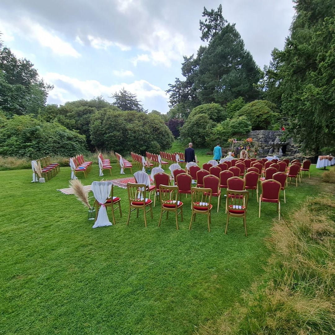 Outdoor wedding ceremony seating arranged in a garden for Deepa and Steve