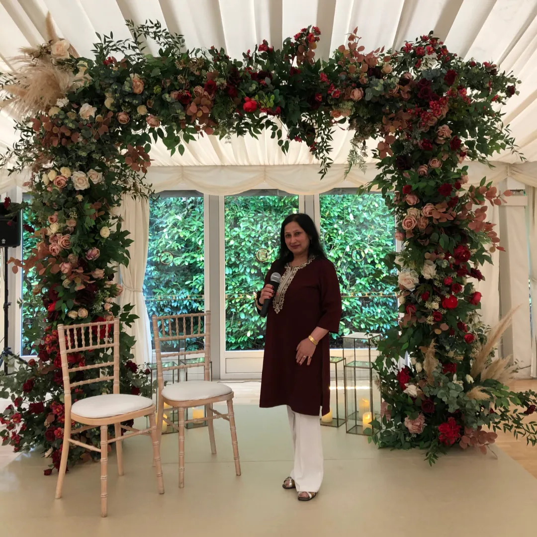 celebrant standing next to wedding arch