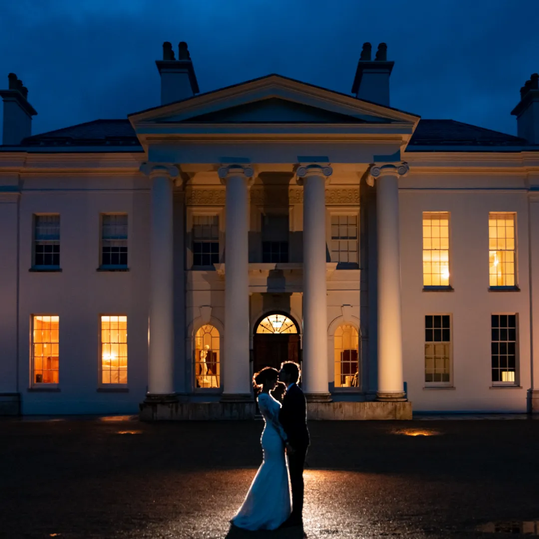 couple kissing in front of wedding venue