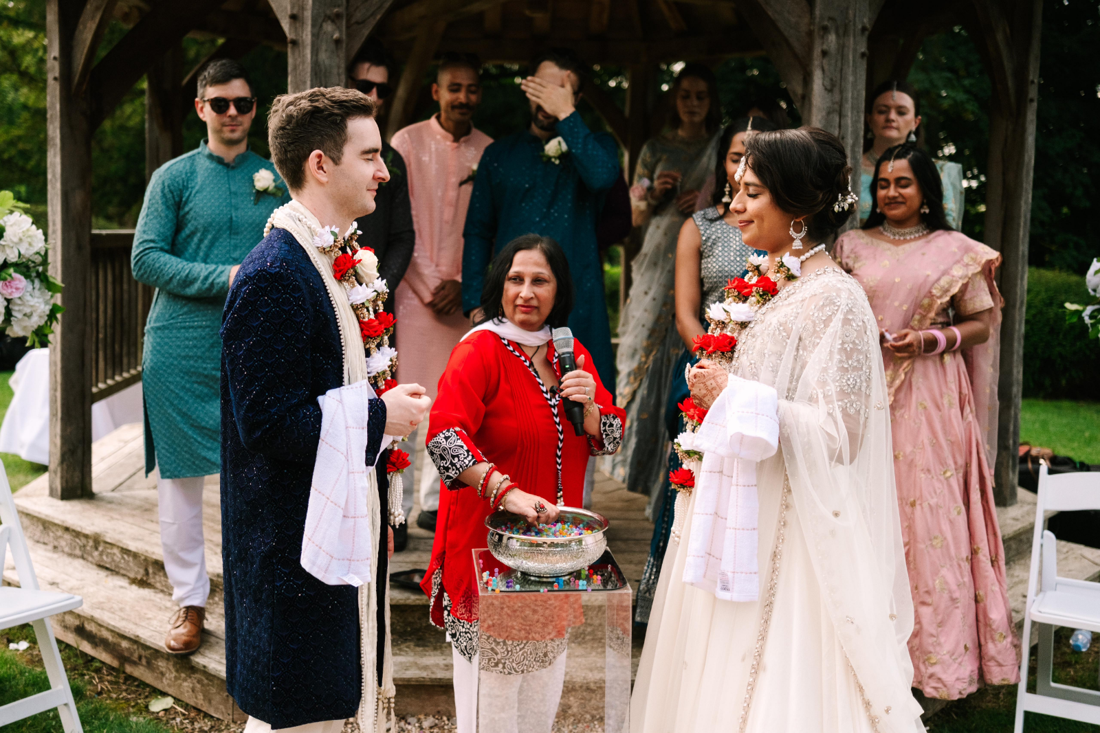 multicultural couple at hotel garden wedding ceremony with garlands