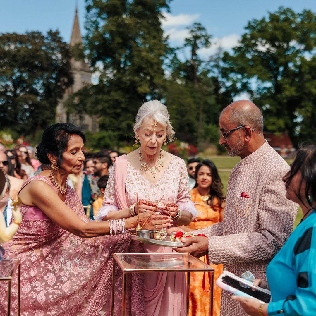 Family members and guests gather around a ceremonial table as preparations take place for Natasha and Aaron’s multicultural wedding ceremony.